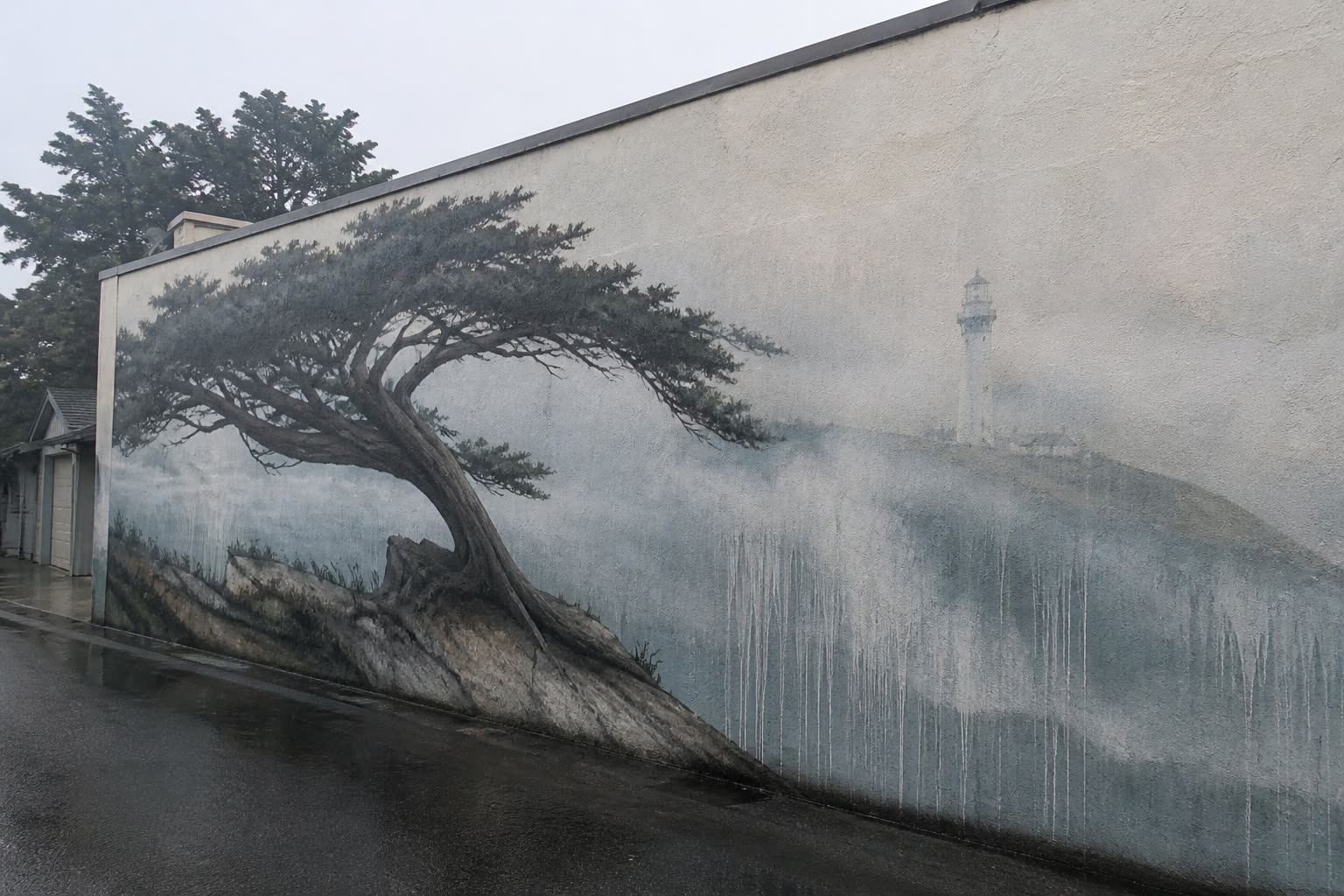 Fog Cap mural: a cypress and lighthouse in marine-layer fog on north-facing stucco